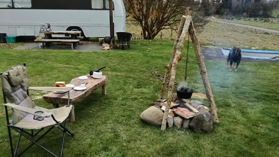 Open campfire with cooking pot and rustic table at Sanctuary Farm