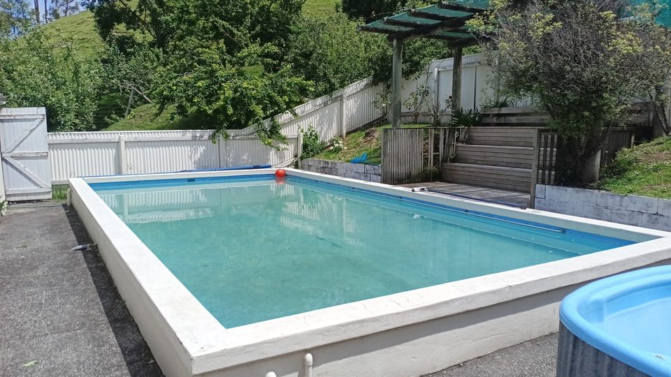 Swimming pool with green hills behind